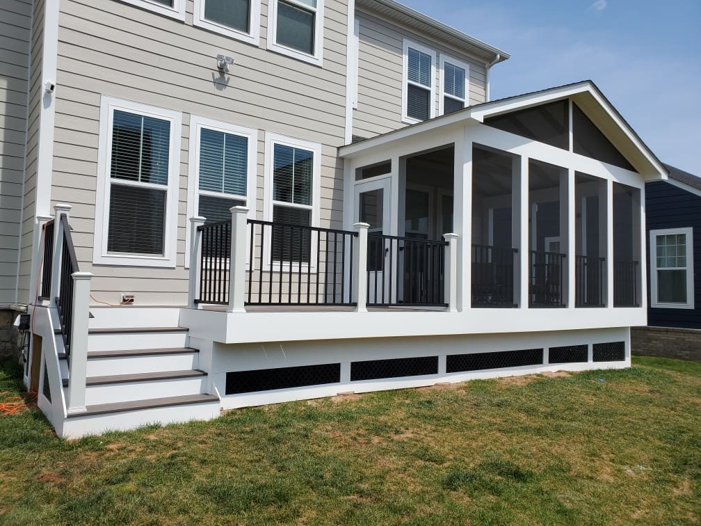 A house with a porch and stairs leading to the back deck.