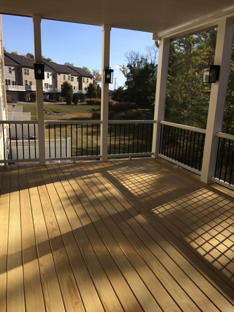 A porch with a view of the lake and trees.