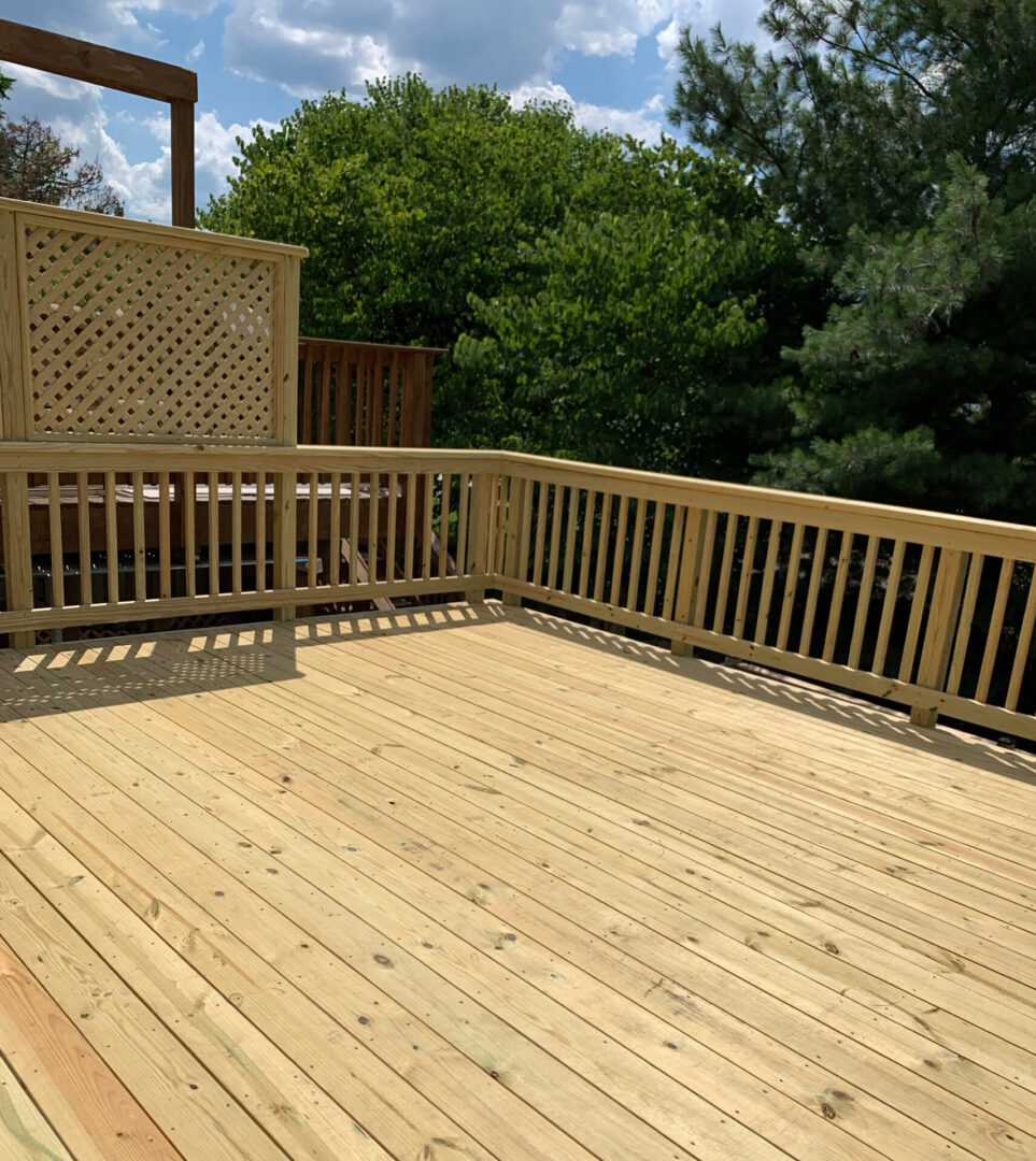 A wooden deck with a bench and a fence.